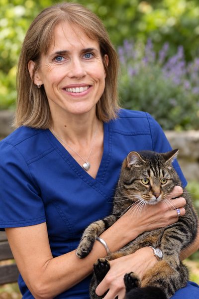 Lucy Hart in scrubs holding a tabby cat